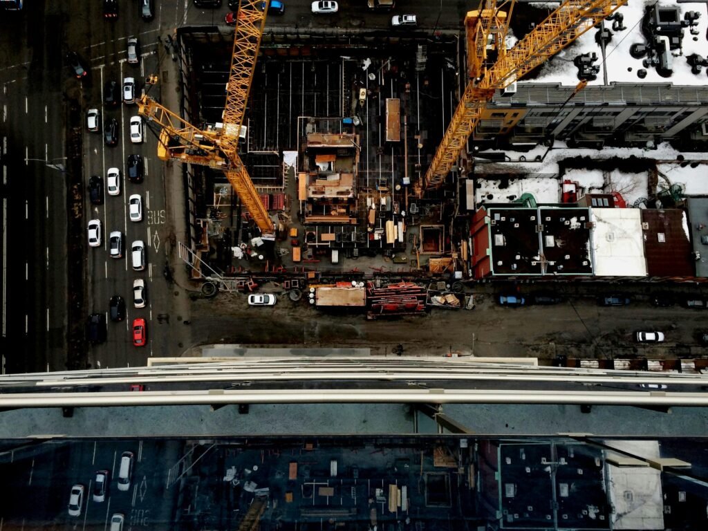 Aerial view of an urban construction site with cranes in Montreal cityscape.